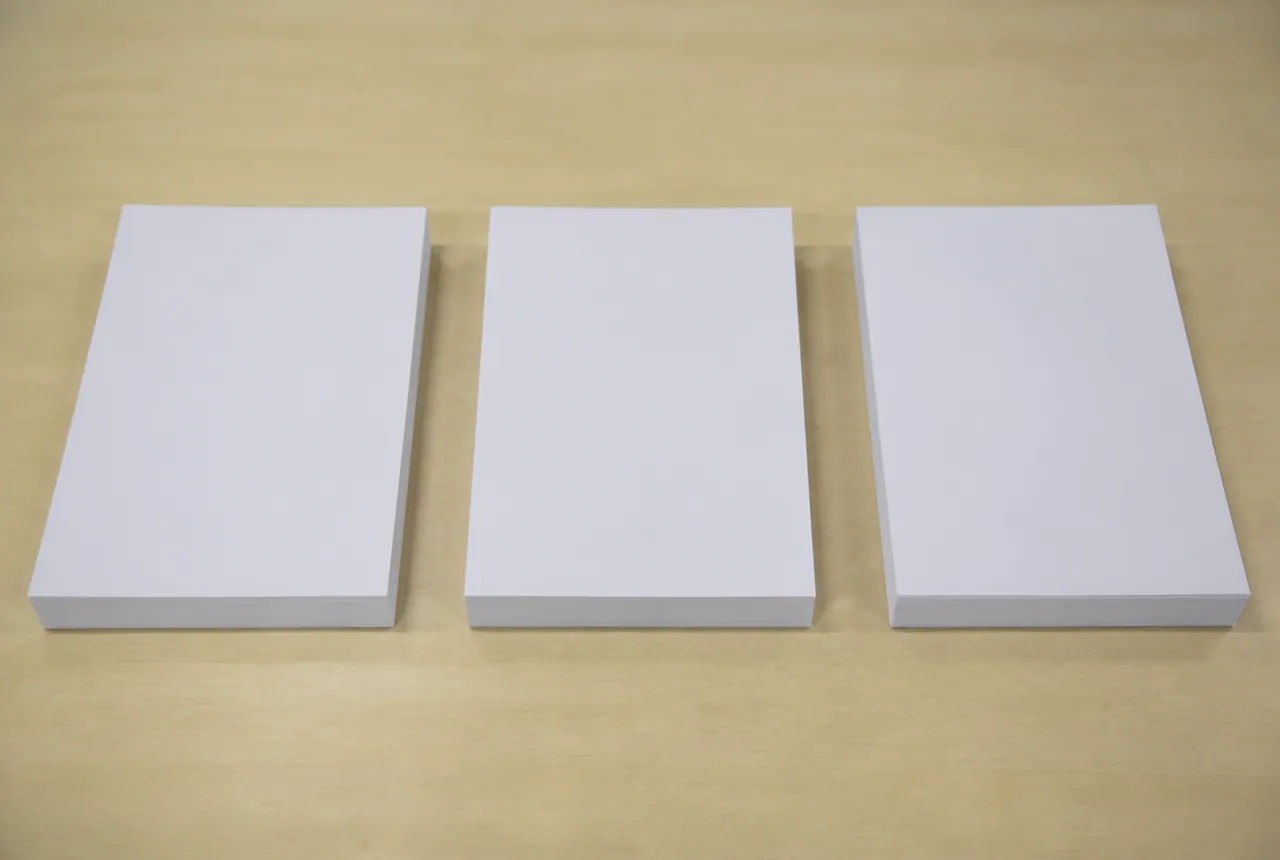 Three blank white document stacks on a tabletop